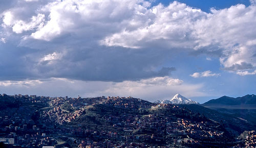 Aerial view of cityscape against cloudy sky