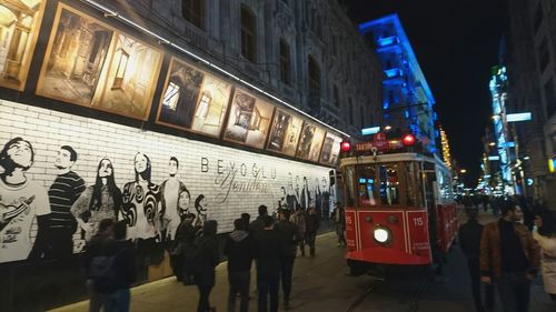 People in illuminated city at night