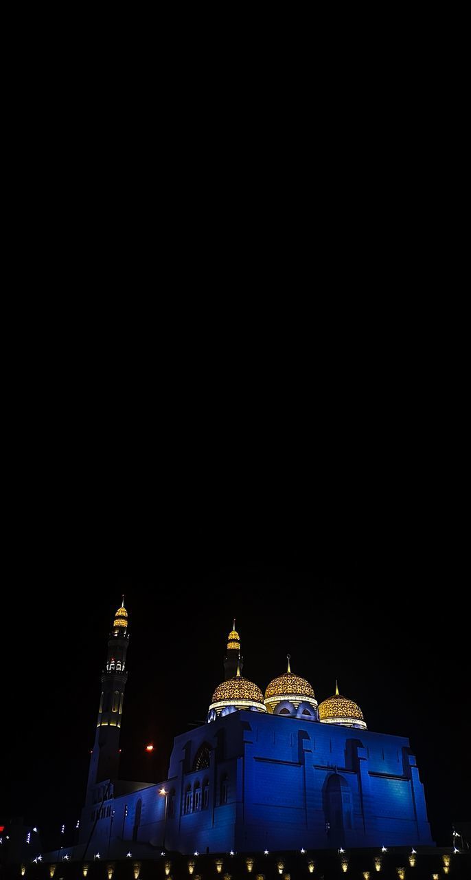 LOW ANGLE VIEW OF ILLUMINATED BUILDINGS AGAINST CLEAR SKY