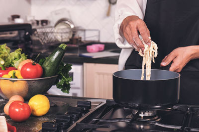 Midsection of male chef preparing food in kitchen