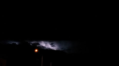 Low angle view of illuminated lights against sky at night