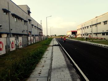 Railroad tracks by buildings in city against sky