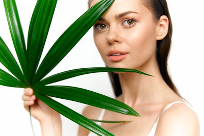 Portrait of young woman with plant