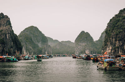 Boats moored in sea against clear sky