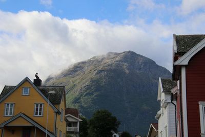 Low angle view of buildings and mountains against sky