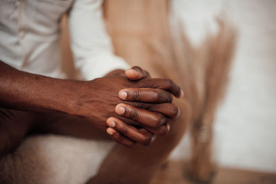 Close-up of man holding hands over blurred background