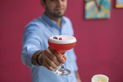 Midsection of man offering drink