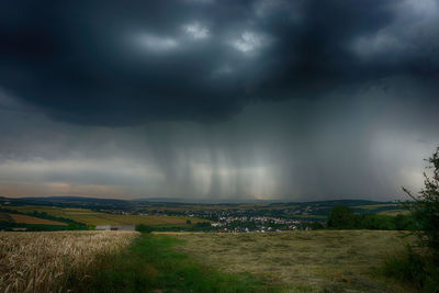 Scenic view of storm clouds over landscape