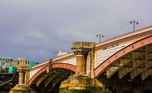 Low angle view of bridge over river against buildings. blackfriars london