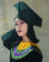 Portrait of beautiful woman standing against wall