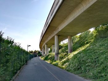 Road leading towards bridge against sky