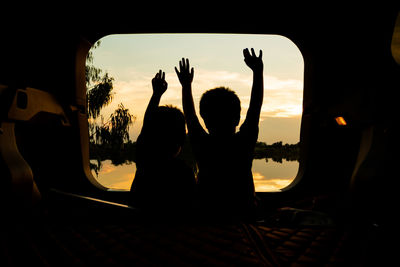 Silhouette of a boy's hand on the back of a utility vehicle