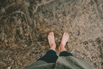 Low section of man standing on beach