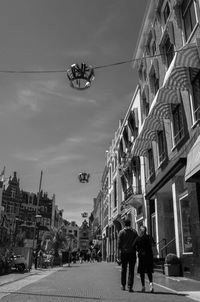 People walking on street amidst buildings in city