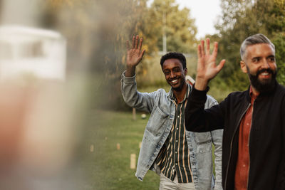 Men in park waving