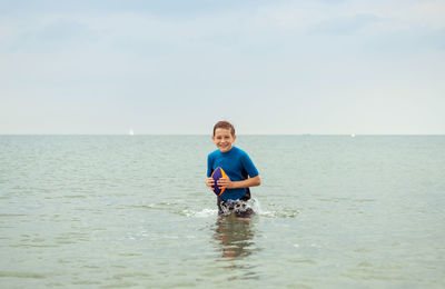 Portrait of boy in sea against sky