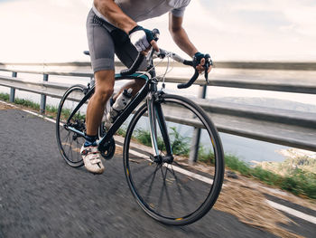 Low section of man cycling on road