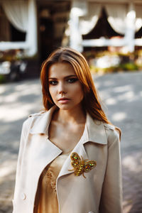 Fashionable young woman wearing overcoat in city