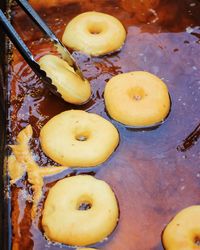 High angle view of donuts being fried in oil at market