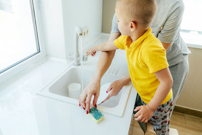 Rear view of siblings playing in bathroom at home