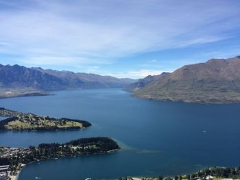 Scenic view of lake and mountains against blue sky