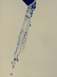 Low angle view of icicles against clear sky during winter