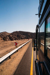 Road by mountain against clear sky