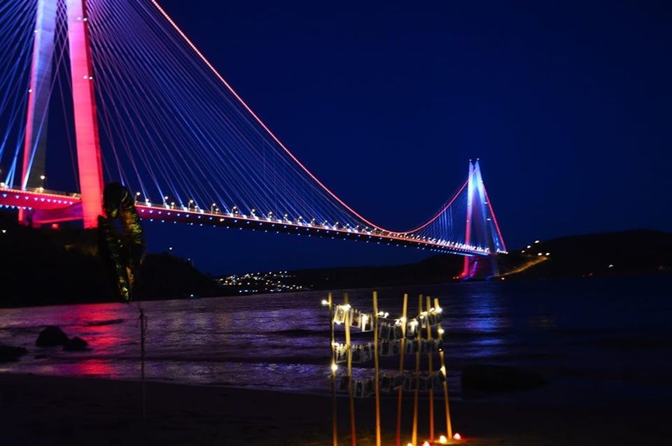 ILLUMINATED SUSPENSION BRIDGE OVER RIVER