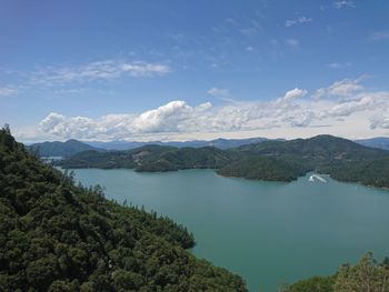 Scenic view of lake and mountains against blue sky