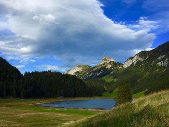 Scenic view of lake by trees against sky