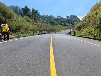 Rear view of man walking on road