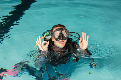 Portrait of smiling young woman swimming in pool