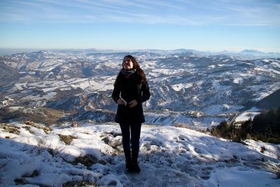 Young woman standing on monte titano against sky during winter