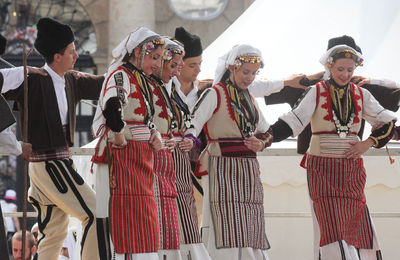 Smiling traditional dancers performing on stage