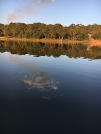 Scenic view of lake by trees against sky