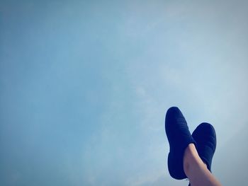 Low section of person against blue sky