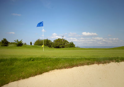 Scenic view of golf course against sky