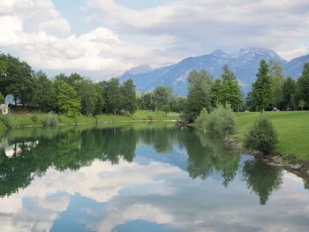 Scenic view of lake by trees against sky