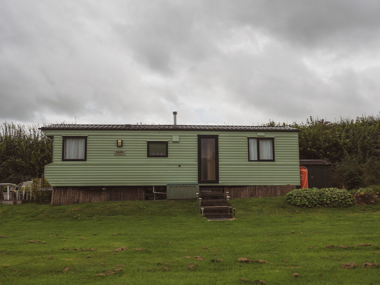 cloud, architecture, sky, rural area, built structure, grass, farm, building exterior, building, house, nature, plant, overcast, no people, land, residential area, home, landscape, storm cloud, storm, outdoors, environment, green, field, tree, rural scene, shed, day