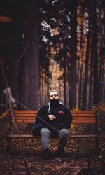 Man sitting on bench at forest