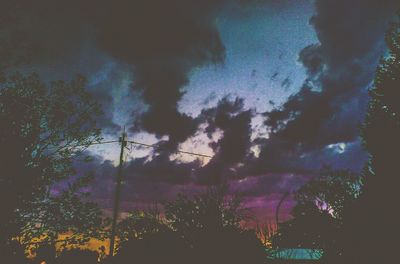 Silhouette trees against sky at night