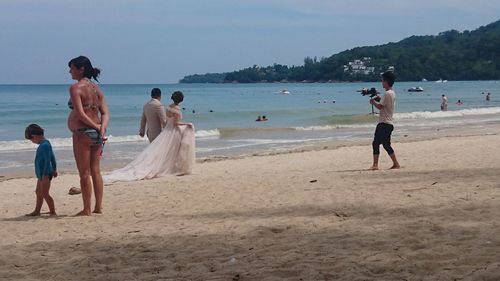 People at beach against sky