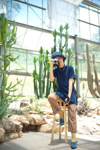 Full length of young man sitting outdoors