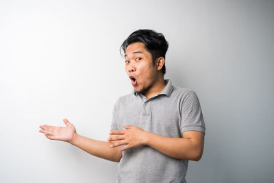 Young man looking away against white background