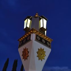 Low angle view of illuminated building against blue sky