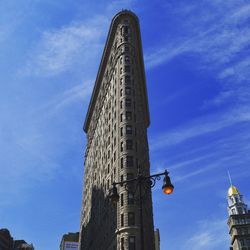 Low angle view of flatiron building against blue sky in new york city.