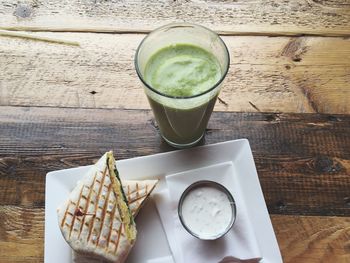 High angle view of coffee and wrap sandwich on table