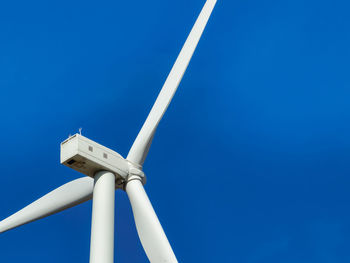 Low angle view of windmill against clear blue sky