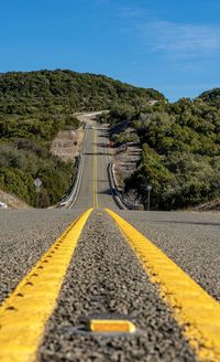 Surface level of road by mountain against sky