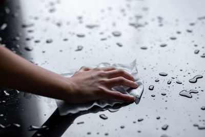 High angle view of woman hand on wet glass